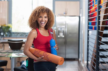 rolled up (closely coiled) - Mid adult woman in holding yoga mat and water bottle, portrait Stock Photo - Premium Royalty-Free, Code: 614-06895901