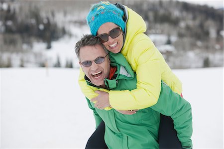 supportive hug - Mature man carrying young woman on back in snow, laughing Stock Photo - Premium Royalty-Free, Code: 614-06896076