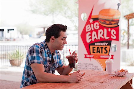 diner - Young man drinking cola in diner, smiling Stock Photo - Premium Royalty-Free, Code: 614-06896112