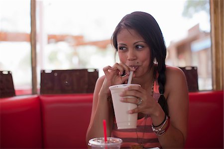 diner - Young woman drinking milkshake in diner, looking away Stock Photo - Premium Royalty-Free, Code: 614-06896126