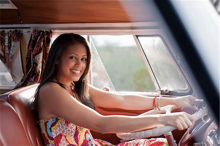 Young woman driving camper van and smiling, portrait Stock Photo - Premium Royalty-Free, Code: 614-06896188