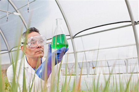 simsearch:6113-07589172,k - Mature scientist looking at liquid in volumetric flask in greenhouse Stock Photo - Premium Royalty-Free, Code: 614-06896326