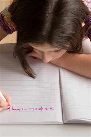 felt tip pen - Girl writing in pink felt tip pen in notebook Stock Photo - Premium Royalty-Free, Code: 614-06896523