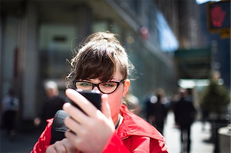 female and outdoor and city daylight - Woman on city street looking at smartphone Stock Photo - Premium Royalty-Free, Code: 614-06896569