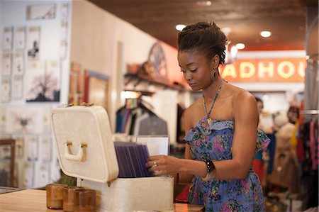 second hand - Young woman looking through box of items in vintage shop Stock Photo - Premium Royalty-Free, Code: 614-06896775