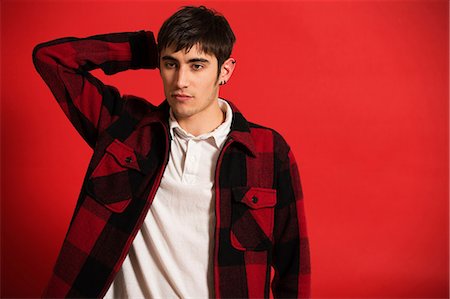 red interiors - Portrait of young man wearing checked shirt Stock Photo - Premium Royalty-Free, Code: 614-06896901