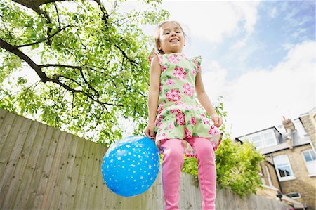 Young girl jumping in garden with balloon Foto de stock - Sin royalties Premium, Código: 614-06896979