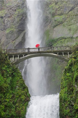 Woman with red umbrella on footbridge over Multnomah Falls, Columbia River Gorge, USA Stock Photo - Premium Royalty-Free, Code: 614-06897053