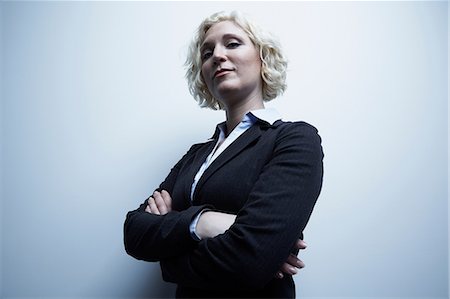 smirk - Studio portrait of businesswoman with arms crossed Stock Photo - Premium Royalty-Free, Code: 614-06897235