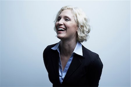 female with jacket looking away - Studio portrait of businesswoman laughing Stock Photo - Premium Royalty-Free, Code: 614-06897238