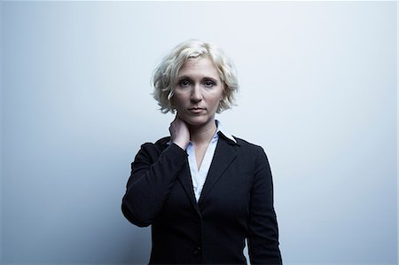 Studio portrait of businesswoman with hand on neck Photographie de stock - Premium Libres de Droits, Code: 614-06897240