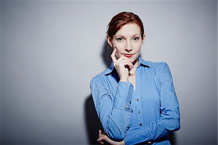 Studio portrait of young woman with hand on chin Stock Photo - Premium Royalty-Free, Code: 614-06897267