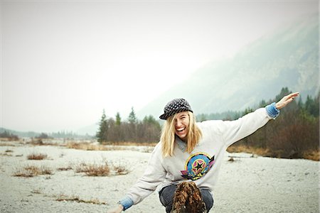 Woman sitting on ground in mountains, laughing Photographie de stock - Premium Libres de Droits, Code: 614-06897505