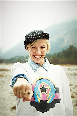 funny fashions - Woman holding hand out and smiling Stock Photo - Premium Royalty-Free, Code: 614-06897501
