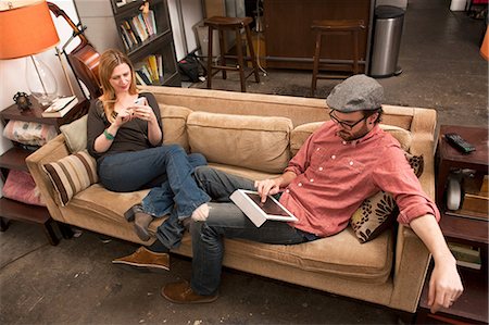 Couple sitting on sofa using digital tablet and smartphone Foto de stock - Sin royalties Premium, Código: 614-06897573