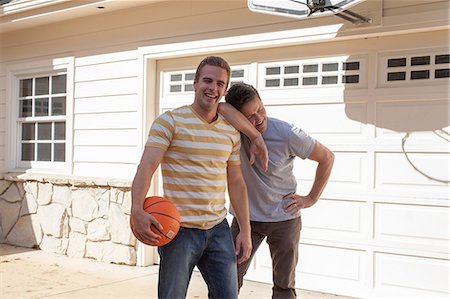 Father leaning on adult son's shoulder with basketball Stock Photo - Premium Royalty-Free, Code: 614-06897679