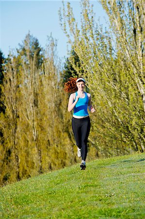 Teenage girl jogging in park Stock Photo - Premium Royalty-Free, Code: 614-06897847