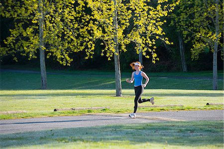 Teenage girl jogging in park Stock Photo - Premium Royalty-Free, Code: 614-06897848