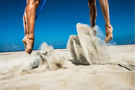 Two beach volleyball players jumping mid air in sand Foto de stock - Sin royalties Premium, Código: 614-06898044