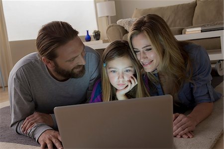 sunlight mature indoors - Parents and child looking at laptop Stock Photo - Premium Royalty-Free, Code: 614-06898285