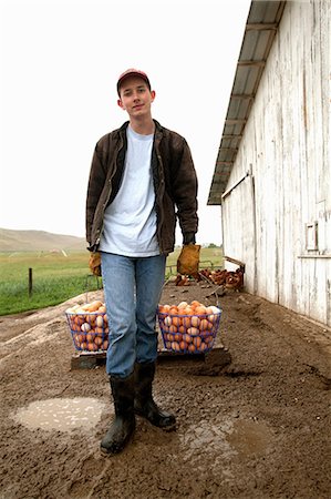 farmer rubber boot - Farmer carrying two baskets of eggs Stock Photo - Premium Royalty-Free, Code: 614-06898456