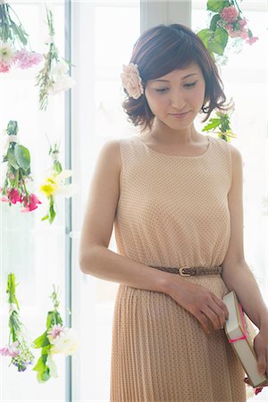 Woman in front of glass door with dangling flowers Stock Photo - Premium Royalty-Free, Code: 614-06898555