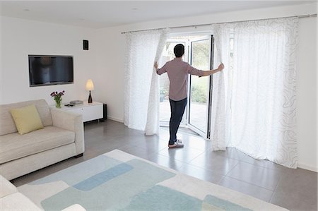 Man looking out of glass door Photographie de stock - Premium Libres de Droits, Code: 614-06898613