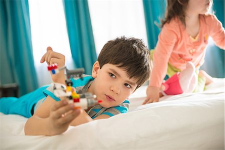 Boy playing with toy in bedroom Stock Photo - Premium Royalty-Free, Code: 614-06974047