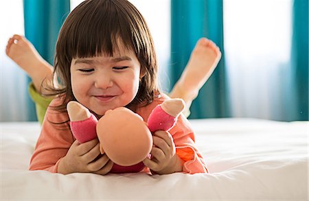 Girl playing with dolly in bedroom Foto de stock - Sin royalties Premium, Código: 614-06974043