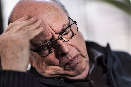 Senior man with eyes closed, wearing glasses, looking stressed Stock Photo - Premium Royalty-Free, Code: 614-06974295