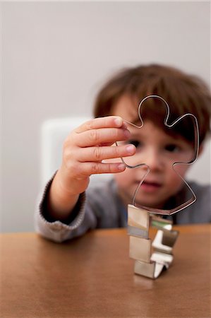 special occasion - Boy looking through Christmas cookie cutters Stock Photo - Premium Royalty-Free, Code: 614-06974298