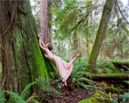 Mature woman holding crystal ball against tree in forest Stock Photo - Premium Royalty-Free, Code: 614-06974600