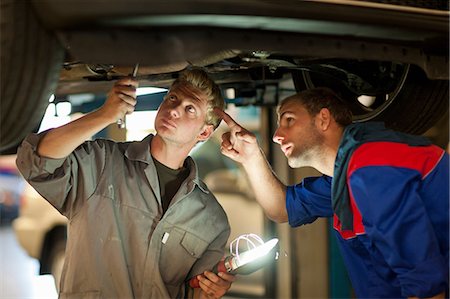 Car mechanics discussing and analyzing car repair Stock Photo - Premium Royalty-Free, Code: 614-06973682