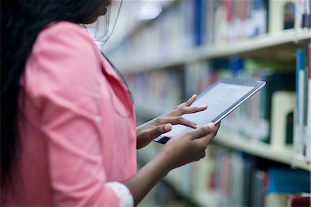 simsearch:614-06973867,k - Female student using digital tablet in library Photographie de stock - Premium Libres de Droits, Code: 614-06973863