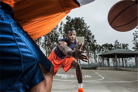 Young basketball players playing on court, close up Stock Photo - Premium Royalty-Free, Code: 614-06973901