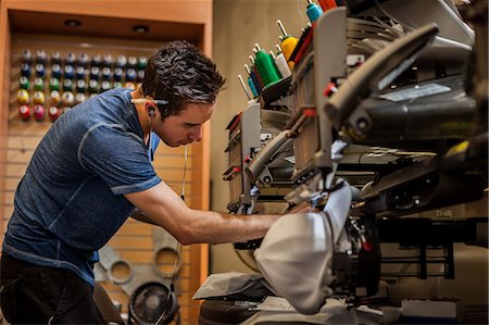 Worker preparing embroidery machine in t-shirt  printing workshop Stock Photo - Premium Royalty-Free, Code: 614-07031295