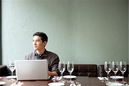 people daydreaming - Young man using laptop in restaurant Stock Photo - Premium Royalty-Free, Code: 614-07031529
