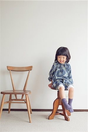 Girl sitting on stool, portrait Stock Photo - Premium Royalty-Free, Code: 614-07031577