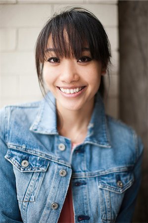 Portrait of young girl in front of brick wall Stock Photo - Premium Royalty-Free, Code: 614-07031907