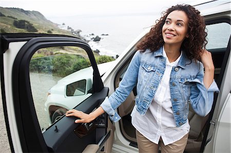 Young woman getting out of car at coast Stock Photo - Premium Royalty-Free, Code: 614-07031939