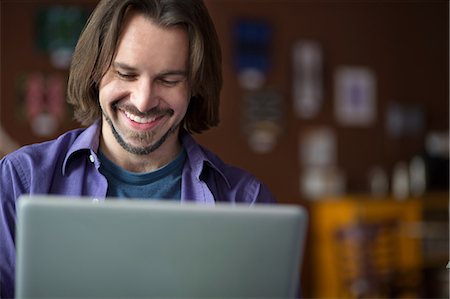 revising - Portrait of young man using at computer in cafe Stock Photo - Premium Royalty-Free, Code: 614-07031986