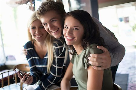 simsearch:614-07031973,k - Group of friends sharing earphones in coffee house Stock Photo - Premium Royalty-Free, Code: 614-07031998