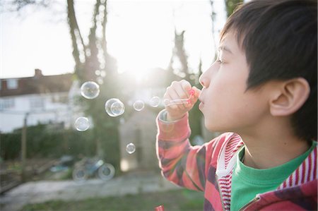 Boy blowing bubbles with wand, close up Stock Photo - Premium Royalty-Free, Code: 614-07032012