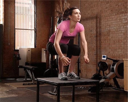 fitness woman - Young woman jumping on table in gym Stock Photo - Premium Royalty-Free, Code: 614-07032217