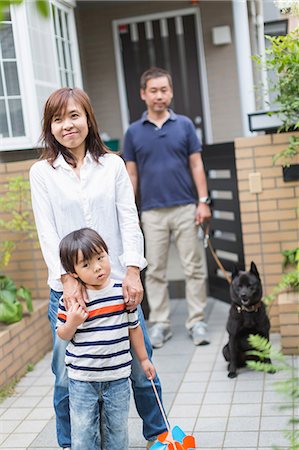 Boy and parents outside home with pet dog Stock Photo - Premium Royalty-Free, Code: 614-07145828