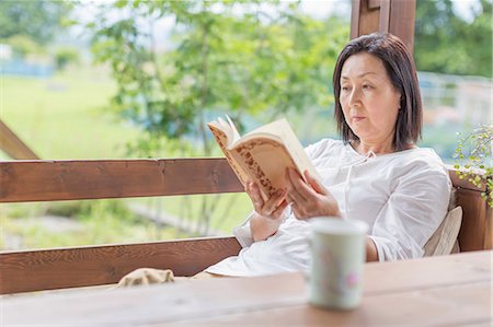 simsearch:614-02985269,k - Woman reading book on patio Stock Photo - Premium Royalty-Free, Code: 614-07145964
