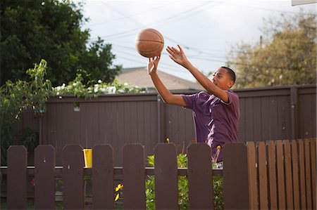 projects - Boy throwing basketball near fence Stock Photo - Premium Royalty-Free, Code: 614-07146356