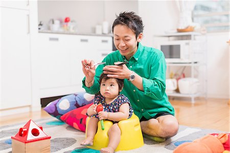 Father cutting baby's hair on floor Stock Photo - Premium Royalty-Free, Code: 614-07194399