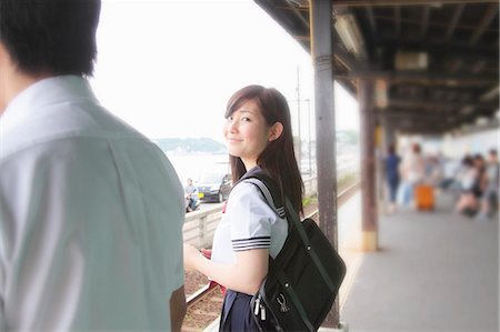 Young woman on railway platform looking at camera Stock Photo - Premium Royalty-Free, Code: 614-07194506