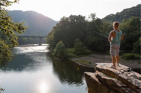 fishing - Young man fishing from rock ledge, Hamburg, Pennsylvania, USA Stock Photo - Premium Royalty-Free, Code: 614-07194672